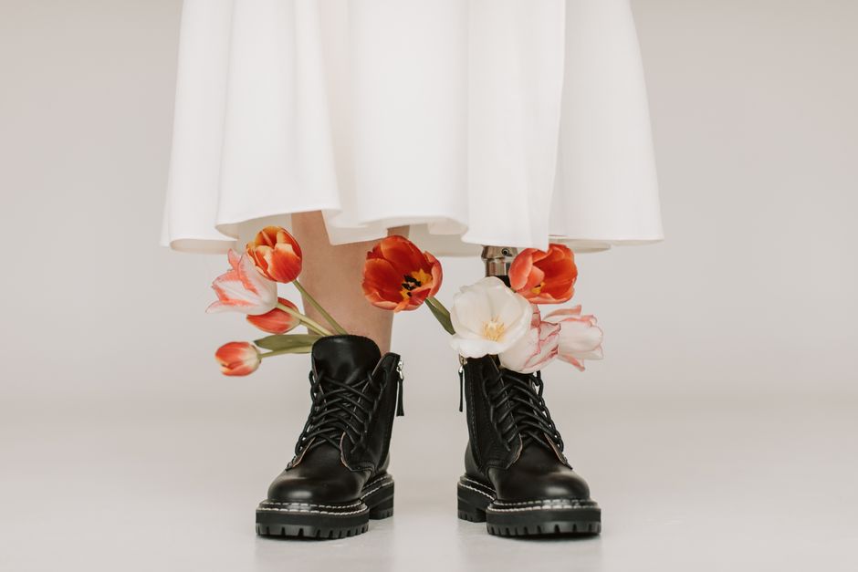 Black lace-up ankle boots worn with a white dress