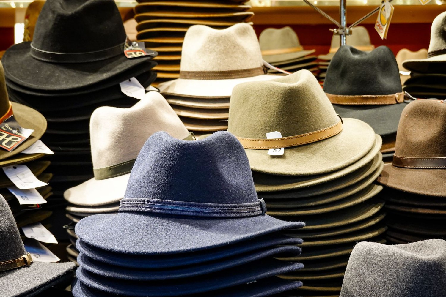 Stacks of felt fedora hats in different colors on display in a hat shop
